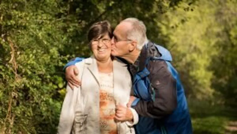 there is a man and woman that are standing together in the woods