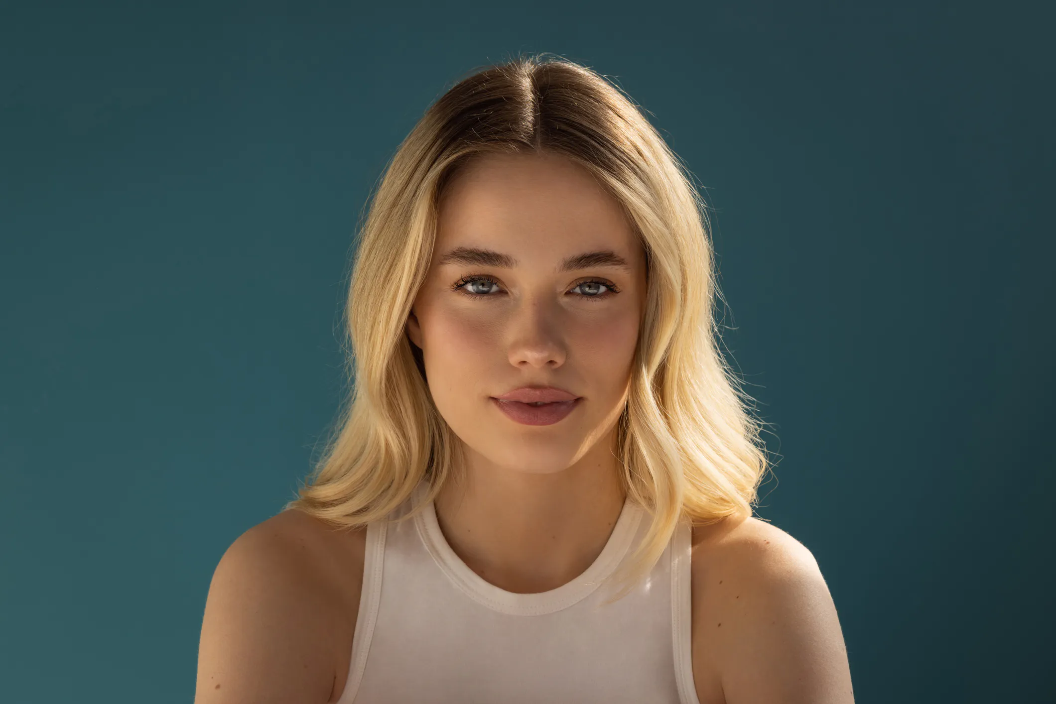 Woman with a slight smile standing in natural light